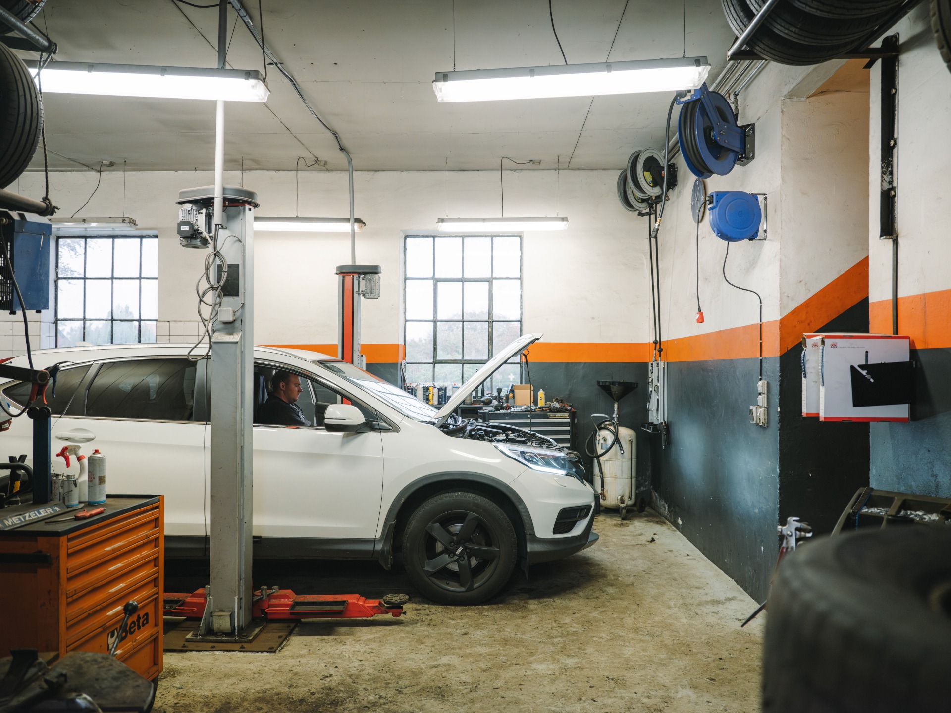 Au2mester E+ services Happy black mechanic working on engine diagnostic at car service